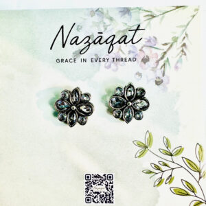 Oxidized silver floral stud earrings with mirror stone detailing by Nazāqat, displayed on a floral backing card