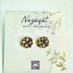 Antique gold floral stud earrings with teardrop stones by Nazāqat, displayed on branded card