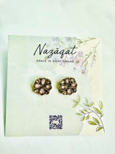 Antique gold floral stud earrings with teardrop stones by Nazāqat, displayed on branded card