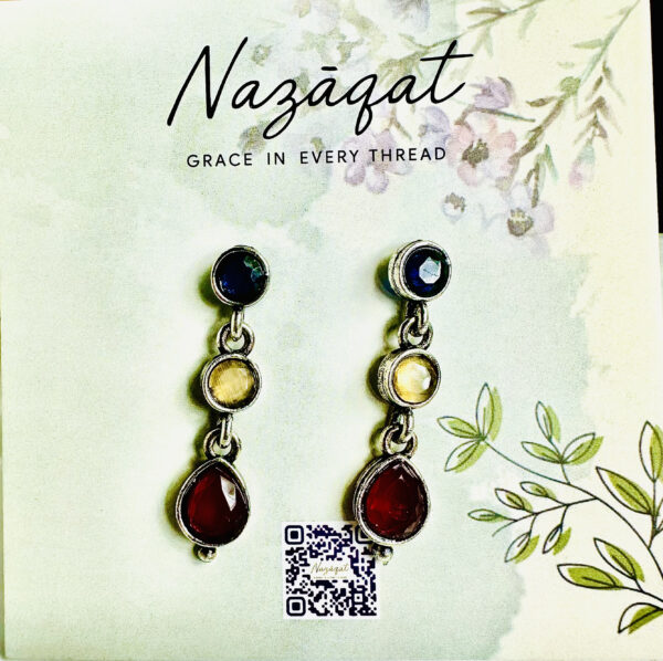 "Elegant handcrafted multi-gemstone drop earrings in navy blue, golden yellow, and deep red by Nazāqat, displayed on a floral card"