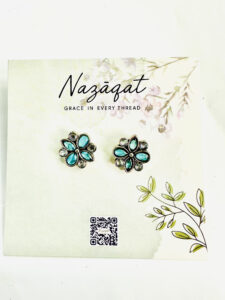 Oxidized silver floral earrings with blue petal-shaped stones and mirror accents by Nazāqat, displayed on a floral card

