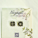 Square oxidized silver stud earrings with central and circular mirror design by Nazāqat, displayed on floral backing