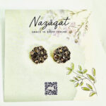 Floral oxidized silver earrings with antique gold and champagne mirror stones by Nazāqat, displayed on floral packaging card