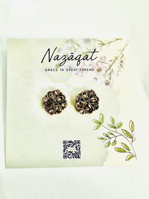 Floral oxidized silver earrings with antique gold and champagne mirror stones by Nazāqat, displayed on floral packaging card