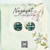 Geometric oxidized silver stud earrings with aqua blue square stones from Nazāqat, displayed on a floral card