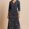 Woman wearing an indigo blue floral printed V-neck belted wrap dress with side slit by Nazāqat